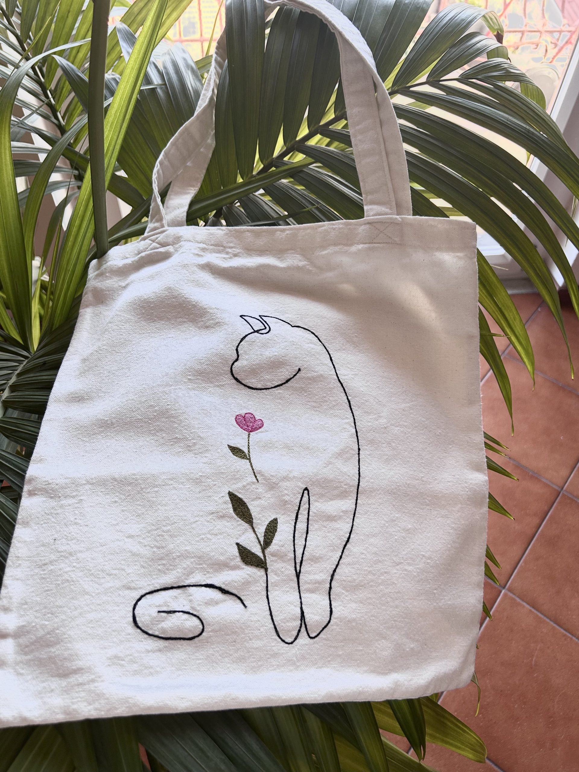Borsa tote fatta a mano in cotone bianco con ricamo di un gatto è un fiore