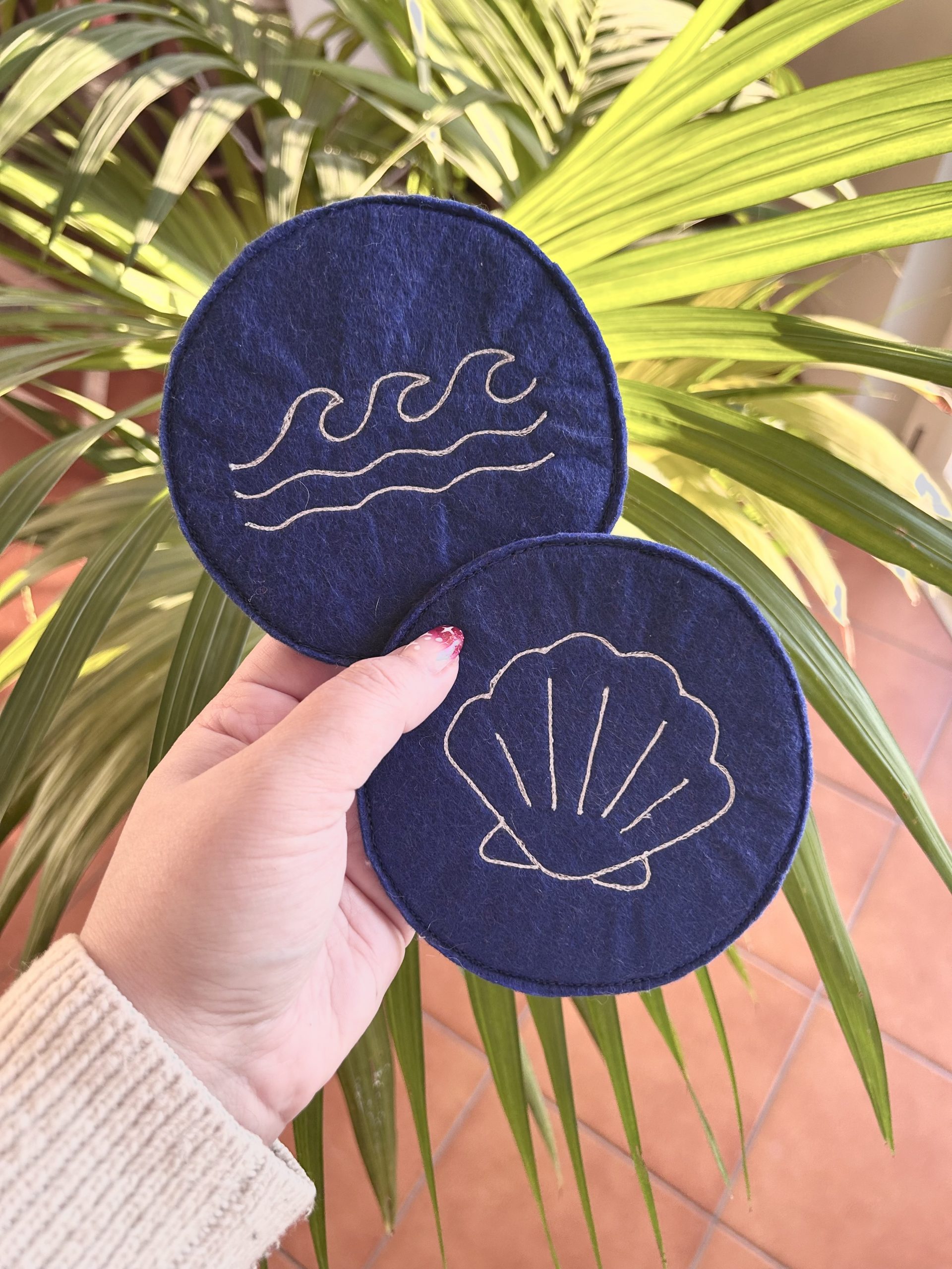 Sottotazza fatti a mano in feltro blu con ricamati una conchiglia e le onde del mare