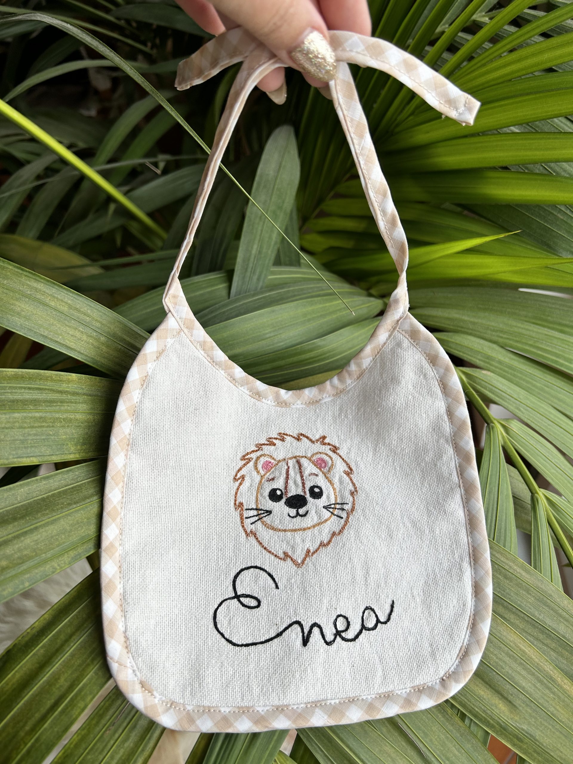 Bavaglino fatto a mano in cotone bianco con ricamato un leoncino e un nome