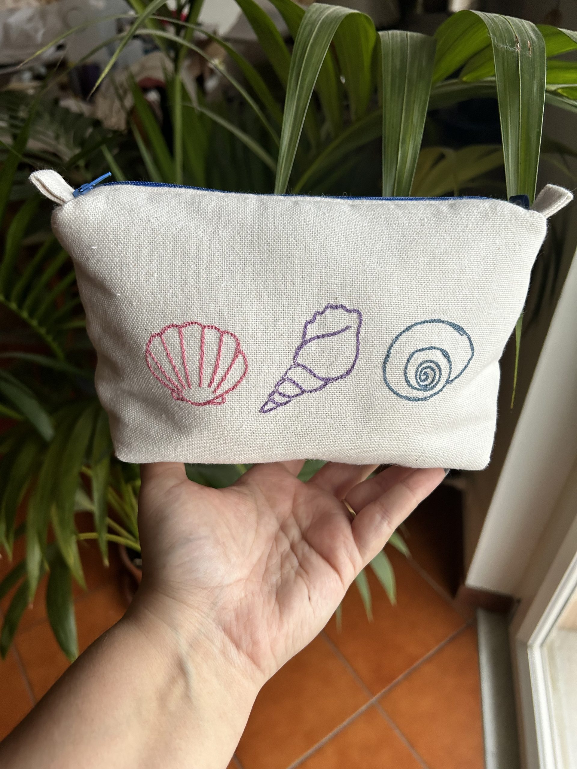 Pochette fatta a mano in cotone bianco con ricamate delle conchiglie colorate
